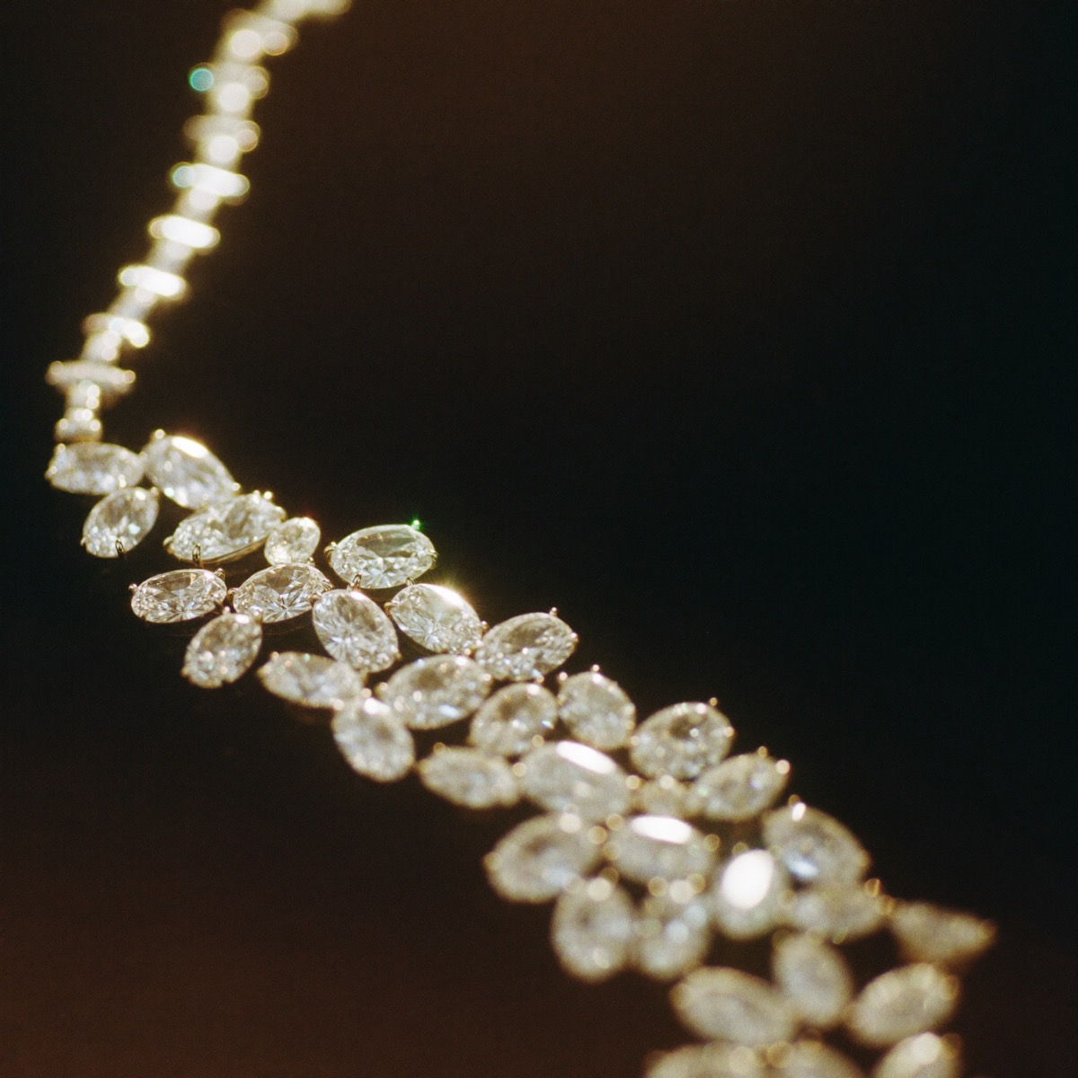 A river of cut diamonds set in a line, glittering warm gold against black